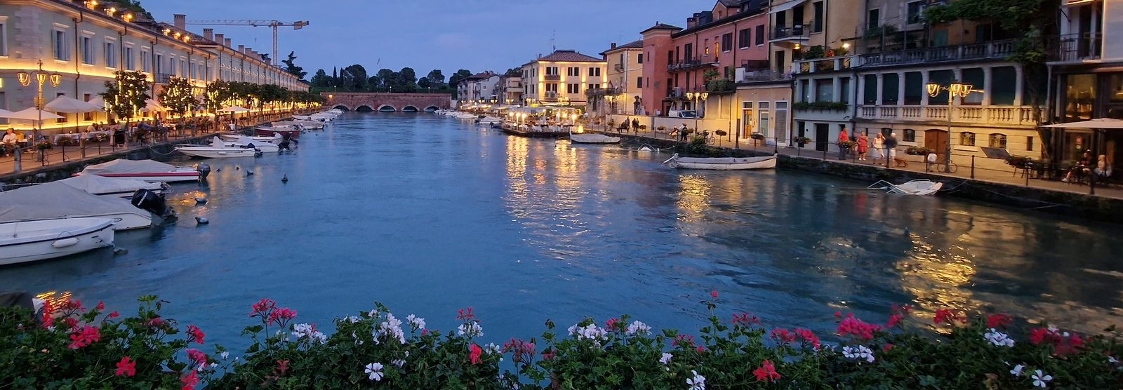 Peschiera in der blauen Stunde, beleuchtete Arkaden am Kanal